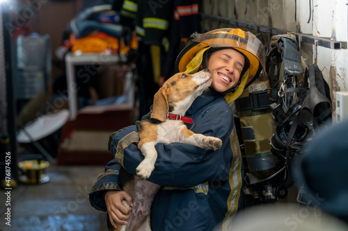 Canvas Print Portrait heroic fireman in protective suit holds saves dog in his arms,Firefighter in fire fighting operation
