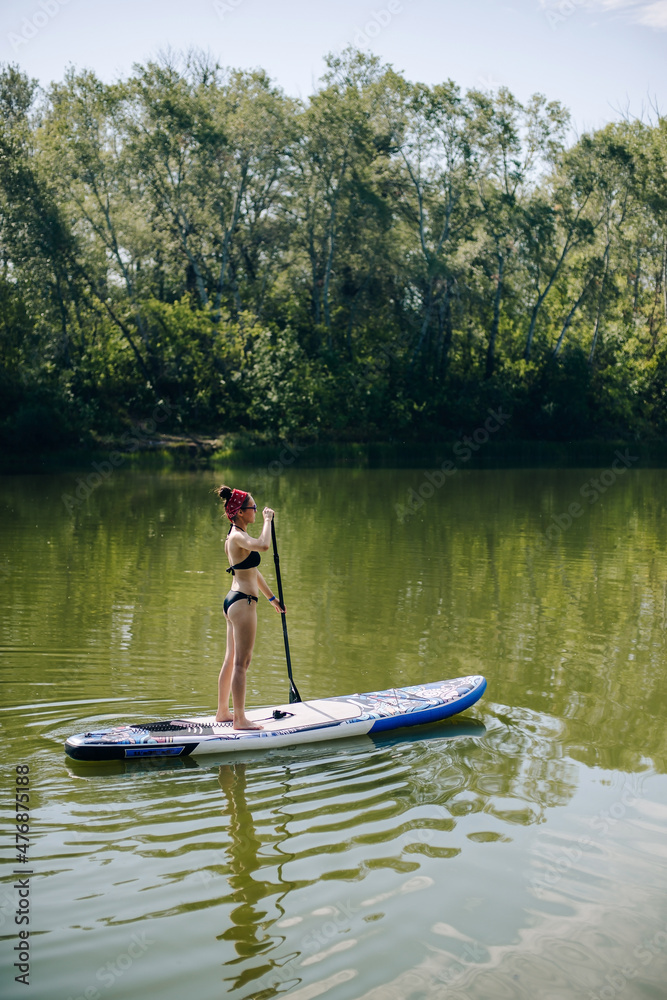 a beautiful girl in a swimsuit is standing on a board