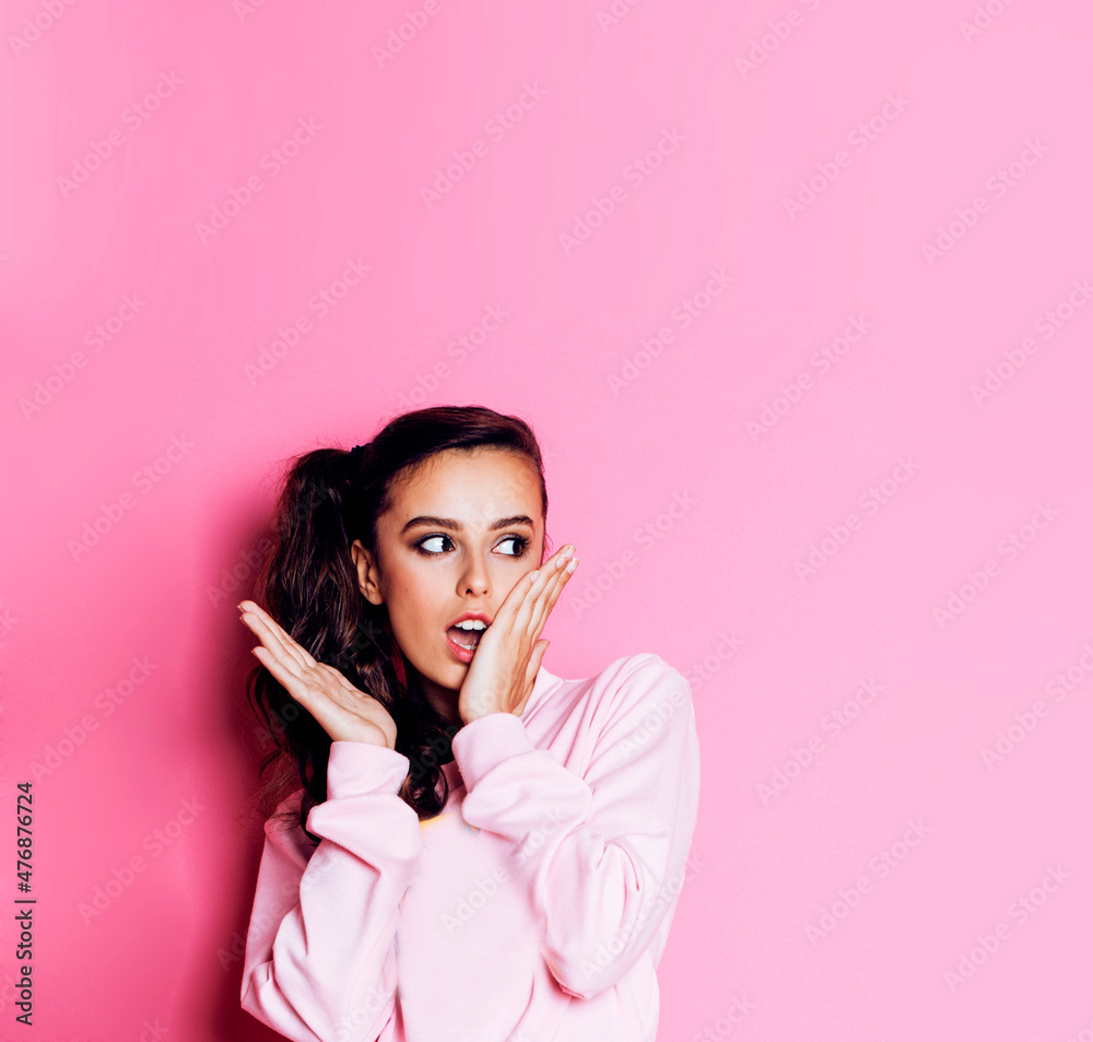 young pretty teenage girl emotional posing on pink background, fashion lifestyle people concept close up copyspace young pretty teenage girl emotional posing on pink background, fashion lifestyle people concept close up copyspace