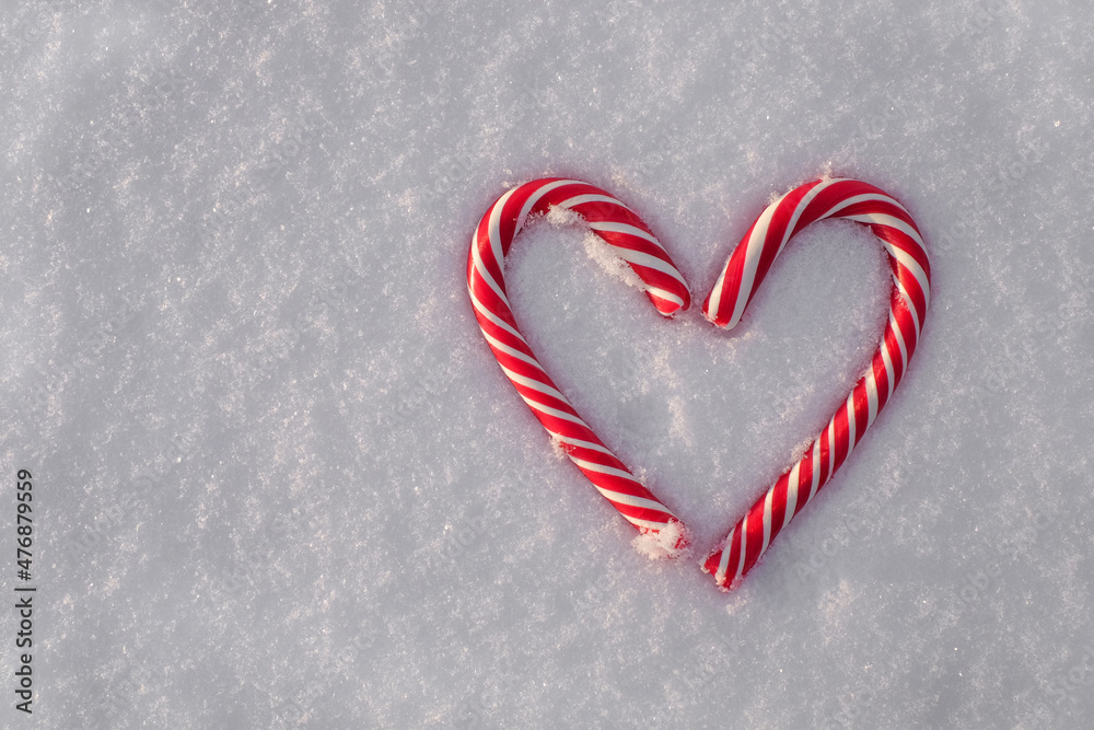 Christmas candy canes as heart on snow backround, copy space, top view