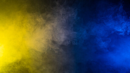 Yellow-blue smoke in neon light on black background.