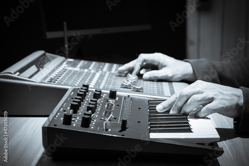 Foto close up male sound engineer, producer hands playing synthesizer keyboard while