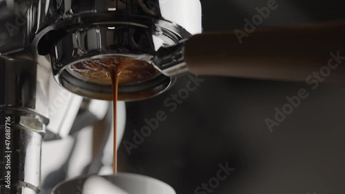 Slow motion pull espresso shot with bottomless portafilter on a professional coffee machine