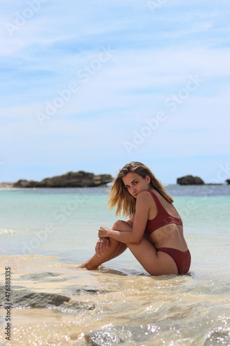 Portrait of a shy young girl sitting on the shore of a beach in Australia © NOWRA photography