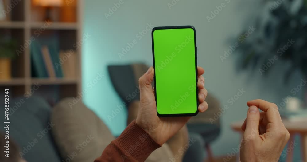 Caucasian man tapping on green screen of mobile