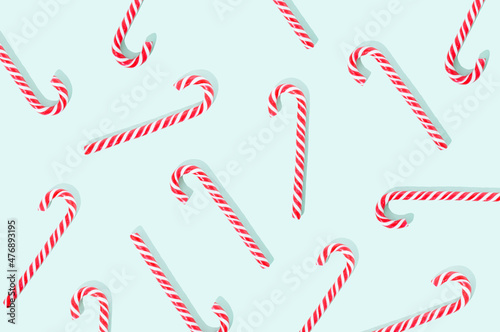 Lollipop candy cane on a pastel green background. Sweet food Christmas concept.