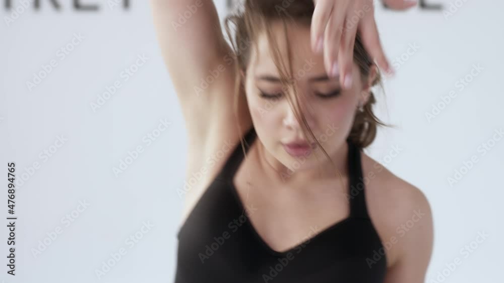 Young preety woman gymnast gesturing with her hands and showing exercises in a studio 4K. Sport, gymnastics, healthy lifestyle concept Young preety woman gymnast gesturing with her hands and showing exercises in a studio 4K. Sport, gymnastics, healthy lifestyle concept