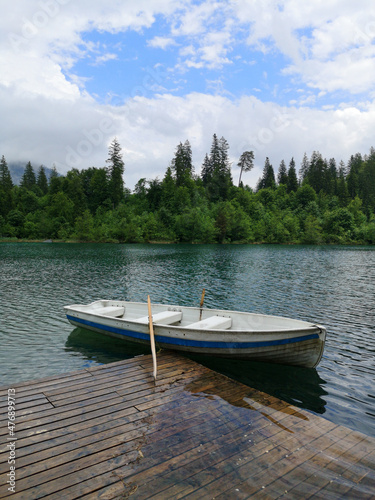 Boat by a pier on Caumasee lake surrounded by trees - Flims  Switzerland