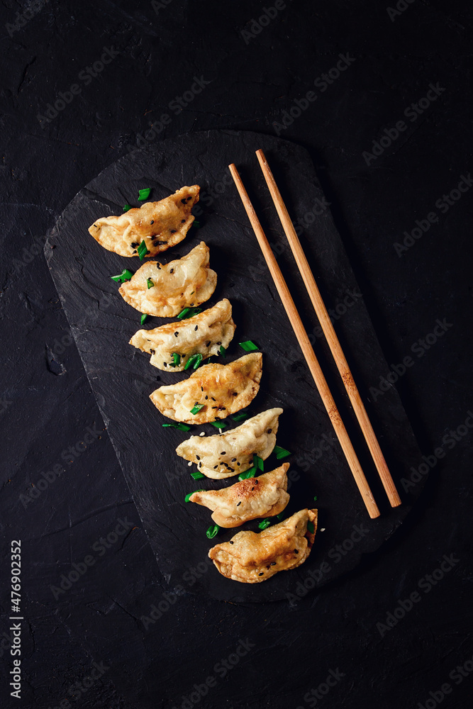 Japanese Gyoza dumplings ,fried, with sauce, on a black background, top view, no people, toned, selective focus, Japanese Gyoza dumplings ,fried, with sauce, on a black background, top view, no people, toned, selective focus,