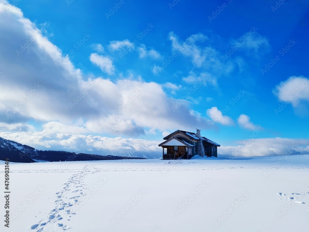 mountain cabin in the distance and snowy and winter landscape