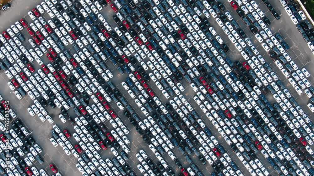Motion over rows of finished cars of different colours at huge open warehouse ground of giant plant bird eye view Motion over rows of finished cars of different colours at huge open warehouse ground of giant plant bird eye view