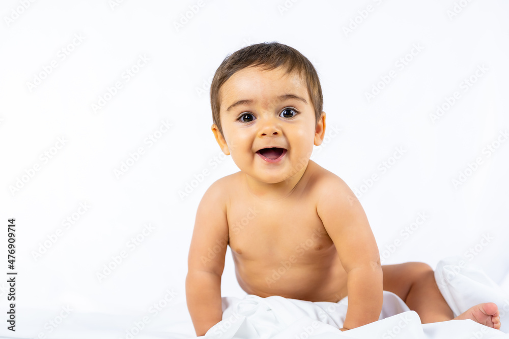 Baby boy in a studio with a white background, eight month old Caucasian newborn sitting looking at camera Baby boy in a studio with a white background, eight month old Caucasian newborn sitting looking at camera
