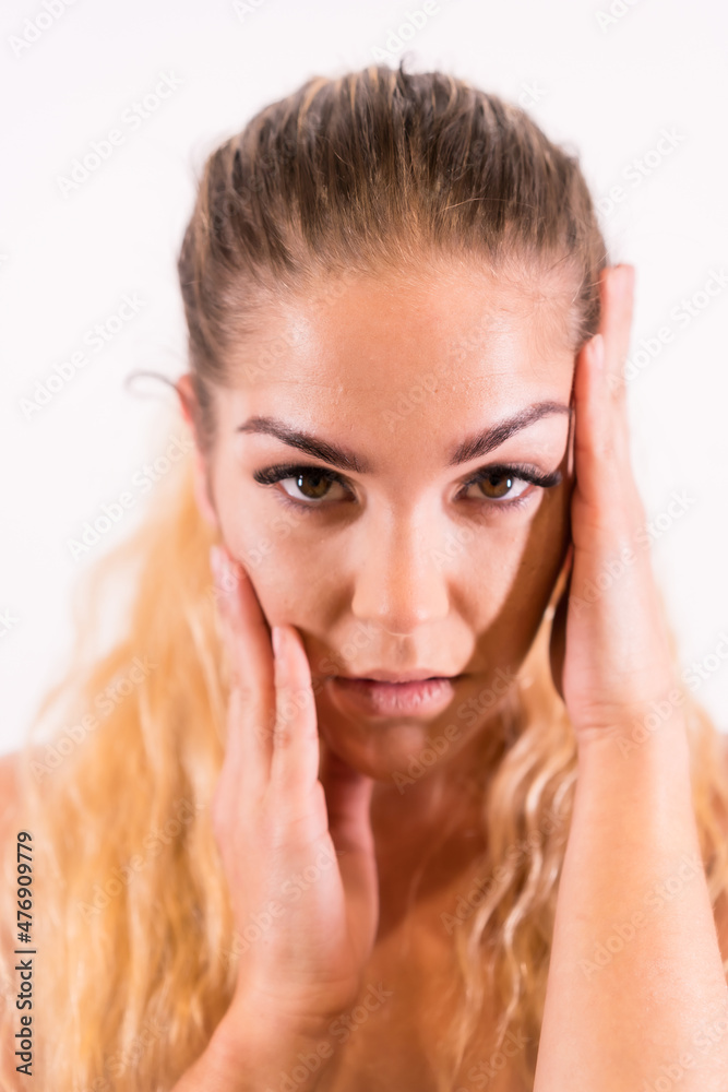 Look of a Caucasian blonde girl with makeup, groomed eyelashes and with a white background, vertical photo Look of a Caucasian blonde girl with makeup, groomed eyelashes and with a white background, vertical photo