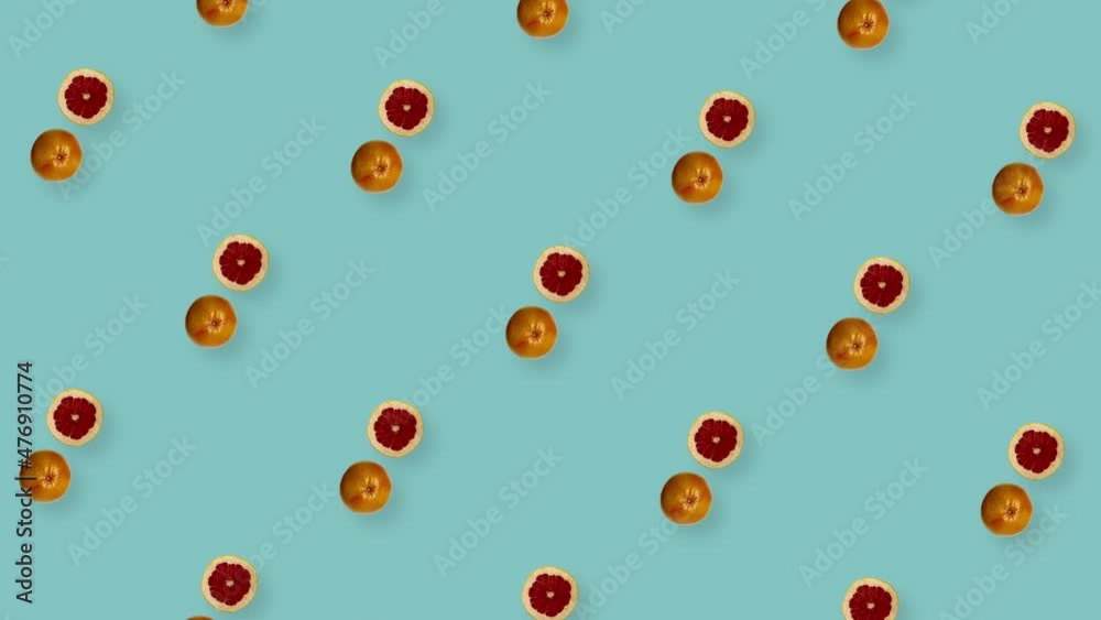 Colorful fruit pattern of fresh rotating grapefruits on blue background. Seamless pattern with grapefruit slices. Realistic animation. 4K video motion Colorful fruit pattern of fresh rotating grapefruits on blue background. Seamless pattern with grapefruit slices. Realistic animation. 4K video motion