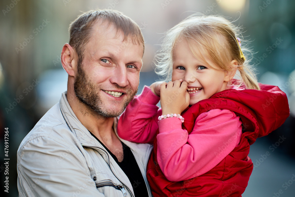 Father and daughter smile while stand outside on street. Father and daughter smile while stand outside on street.