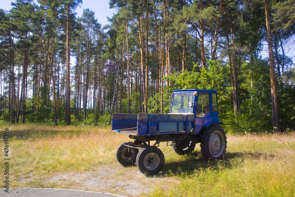 Blue tractor at the edge of the forest Blue tractor at the edge of the forest