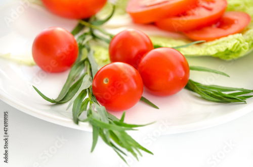 Tomatoes and green leaves on a white background