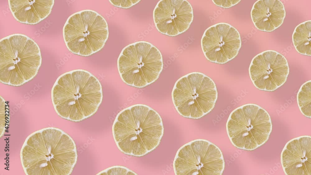 Colorful fruit pattern of fresh lemons on pink background with shadows. Seamless pattern with lemon slices. Realistic animation. 4K video motion