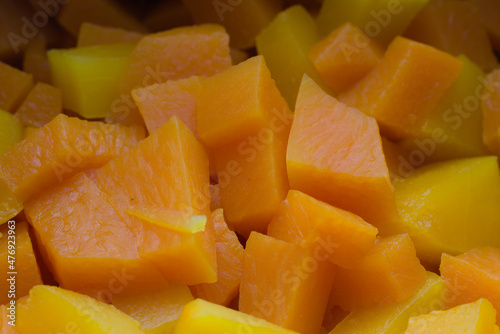 Slices of raw pumpkin with orange-yellow flesh. Autumn vegetarian cooking.