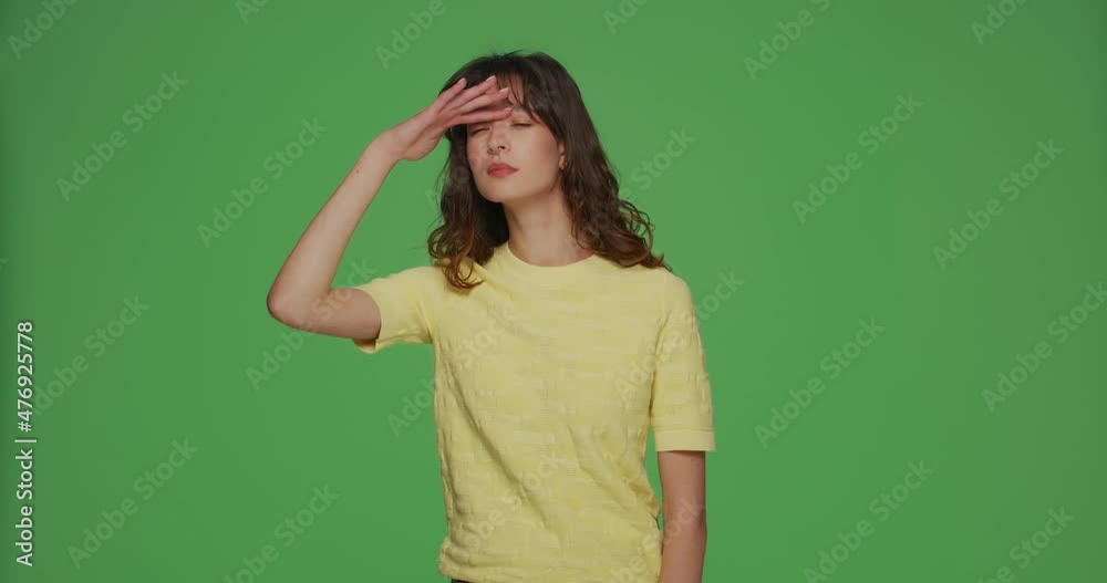 Focused attentive girl looking around with hand over forehead, search, detect finding on chromakey green background
