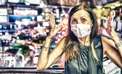 Terrified woman in the city traffic wearing breathing mask for pollution and coronavirus