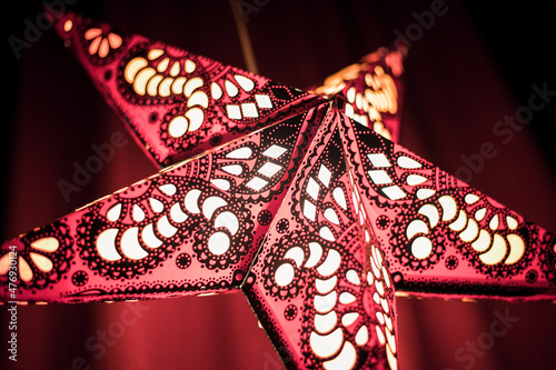 Christmas star with beautiful lighting and red background, christmas deoration. Holiday Season