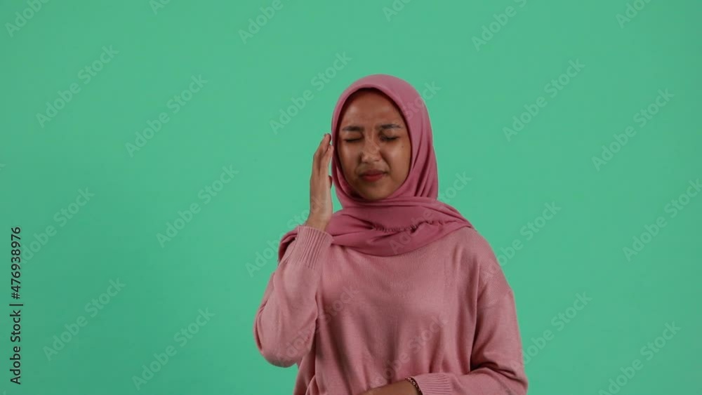 Asian woman got headache isolated on green background Asian woman got headache isolated on green background