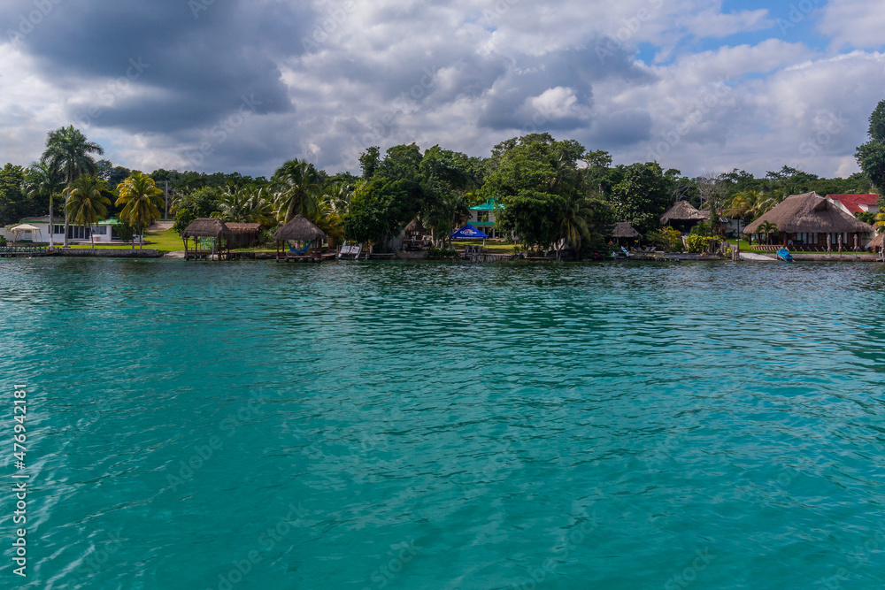 Palms and houses on the lagoon, Laguna Bacalar, Chetumal, Quintana Roo, Mexico.