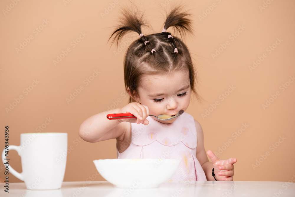 Kid eat healthy nutrition, baby food. Babies eating with spoon. Lick tasty spoon. Portrait of cute Caucasian child kid with spoon. Hungry messy baby with plate after eating puree. Kid eat healthy nutrition, baby food. Babies eating with spoon. Lick tasty spoon. Portrait of cute Caucasian child kid with spoon. Hungry messy baby with plate after eating puree.