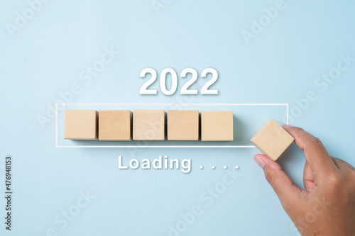 Loading new year 2021 to 2022 with hand putting wood cube in progress bar