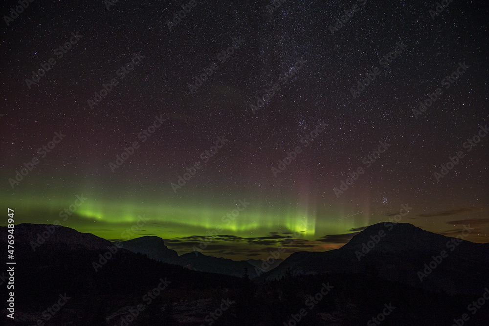 A beautiful green and red aurora dancing in Sunshine Village, Canada