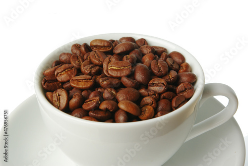 White cup of coffee full of coffee beans on a saucer. Coffee concept. Isolated on white.