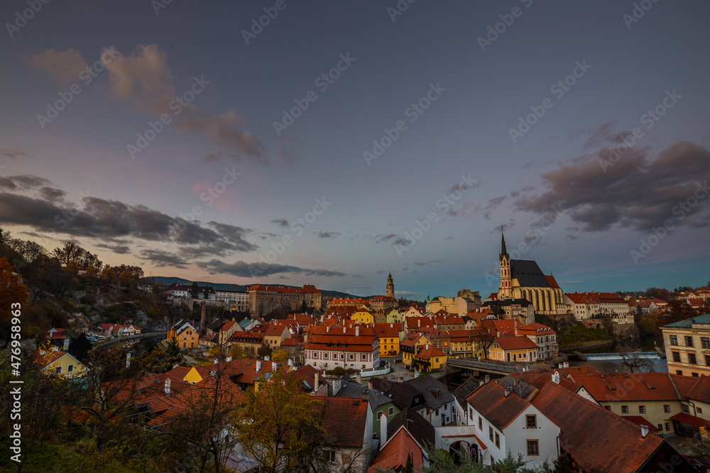 Evening lights illuminate the sky above medieval town of Cesky Krumlov, Czech Republic