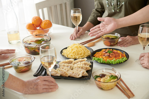 Delicious food like gyoza  noodles  soup and salad on dinner table for party of senior friends