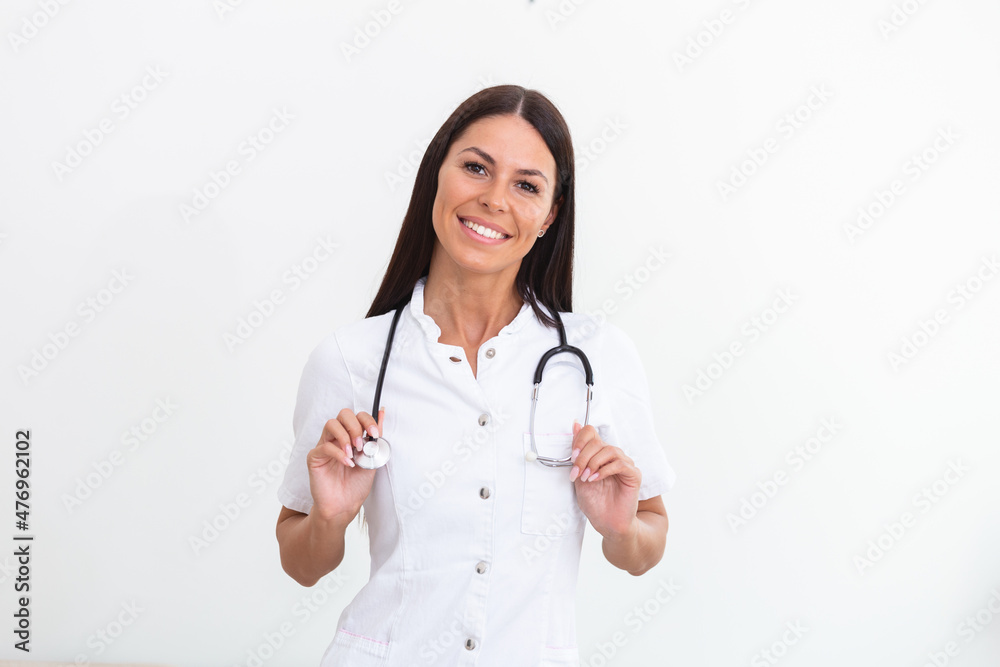 Woman doctor wearing white coat stethoscope on shoulders looking at camera. Confident female doctor smiling at camera, health care and prevention concept Woman doctor wearing white coat stethoscope on shoulders looking at camera. Confident female doctor smiling at camera, health care and prevention concept
