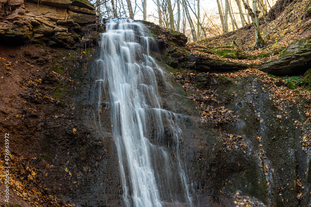 Fototapeta premium Tranquil waterfall scenery in the middle of autumn forest