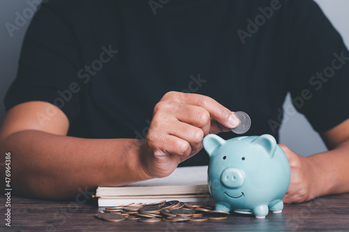 business finance saving and investment concept. hand put money coin into piggy bank for financial saving money, vintage picture style business concept.