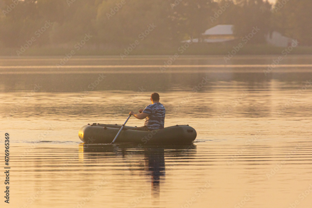 A man floats in a boat on the lake