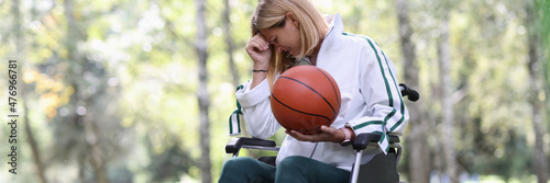 Disabled woman in wheelchair holding basketball ball and crying Fotobehang