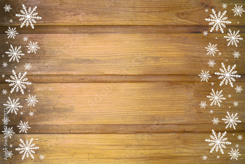 Winter wooden beige yellow brown nature background with snowflakes two sides. Texture of painted wood horizontal boards. Christmas, New Year card with copy space.