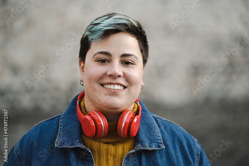 Handsome non-binary woman smiling outdoors photo