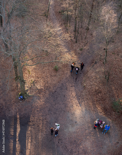 birds eye view of people walking in sunny winter forest near doorn in the nether Fototapet