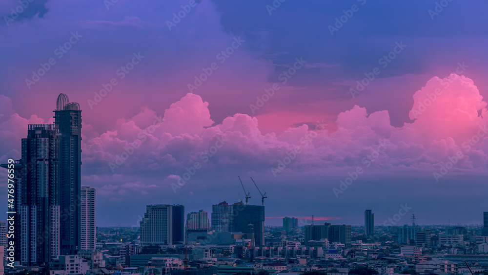 Fototapeta premium The high angle background of the city view with the secret light of the evening, blurring of night lights, showing the distribution of condominiums, dense homes in the capital community