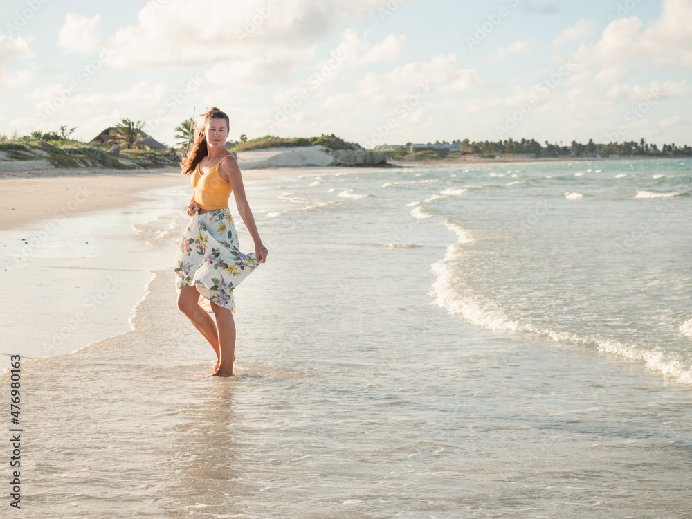 Young woman walking along the coast of the Atlantic Ocean. Close-up. Vacation and travel concept