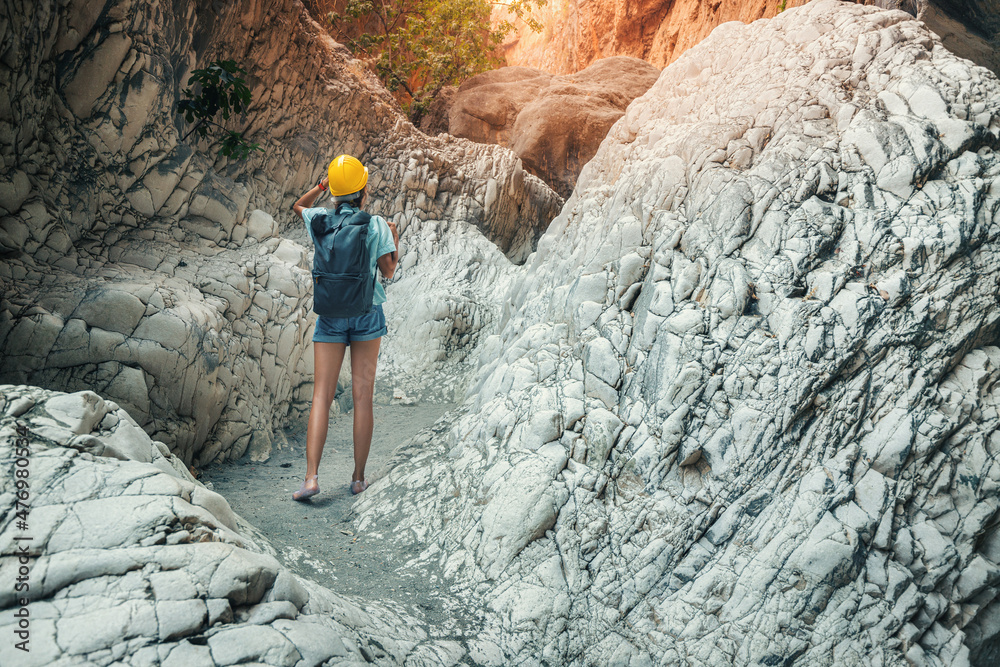 Fit woman in helmet is engaged in canyoning and hiking along the Saklikent Gorge in Turkey. Exploration and outdoor leisure activities and recreation