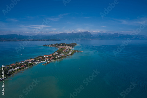 Aerial view of the island of Sirmione. Sirmione, Lake Garda, Italy. Panorama of Lake Garda. Castle on the water in Italy. Peninsula on a mountain lake in the background of the alps. © Berg