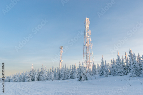 Snow communication towers on the top of the mountain, surrounded by snowy Christmas trees