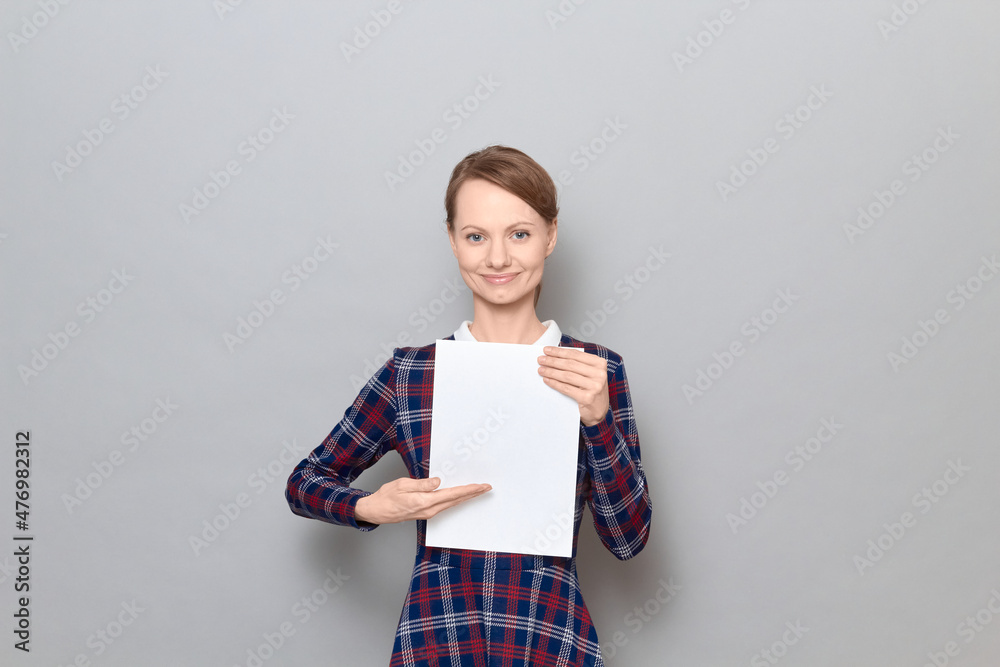 Portrait of happy young woman holding white blank paper sheet Portrait of happy young woman holding white blank paper sheet