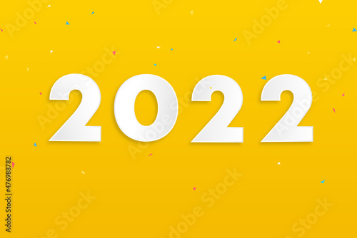 Numbers 2022 on yellow background with colorful confetti for new year concept