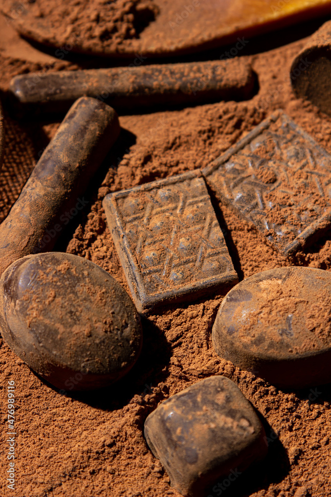 Chocolates lie on cocoa powder. Chocolate making concept. Chocolate sprinkled with cocoa. Cinnamon chocolates. Chocolates lie on cocoa powder. Chocolate making concept. Chocolate sprinkled with cocoa. Cinnamon chocolates.
